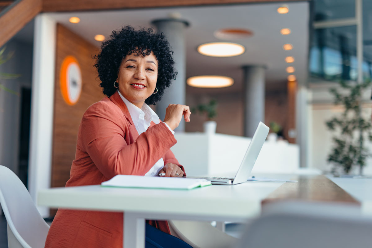 Portrait of Mature female entrepreneur brainstorming while using a laptop computer in the office.