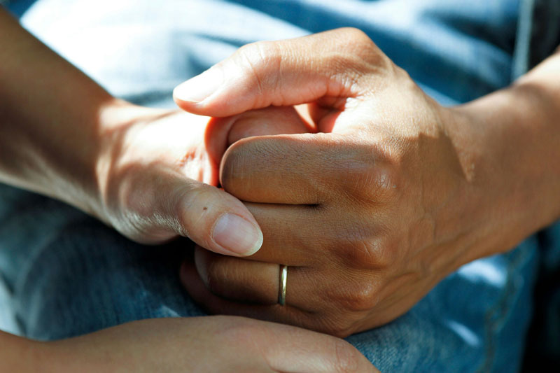 Couple clasping hands in a hospital